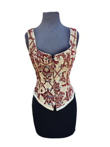 A Shrine classic!! A heavily constructed corset top in rich burgundy and ivory tapestry fabric with a great form fit. Heavy metal boning at sides and lycra stretch panel at back adds extra strong support. Fastens in front with seven large kilt pins but also zips in back for easy access. Rich ivory satin piping around armholes and neckline and ivory satin lining inside. Trimmed at the bottom with braided trim. This is one of our favorites! A very flattering fit. 