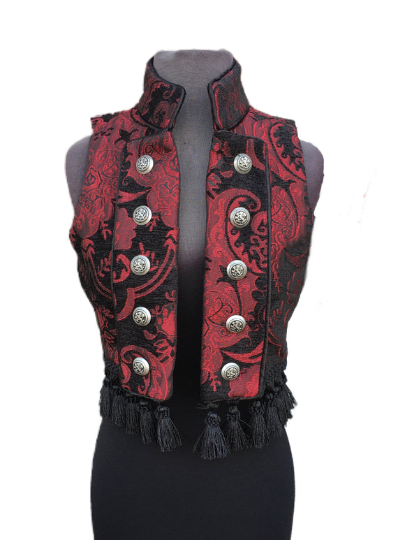 A beautiful gypsy/bellydancer/burlesque vest from the old country. A short vest with a stand-up collar in vintage european style, made in lush red/black tapestry fabric with black satin lining inside. Exquisite black satin piping trim all over. Front fastens back with ornate metal medieval lion buttons or can be undone and crossed over worn double-breasted fashion. Elaborate black tassel trim at the bottom. Great for any gothic, steampunk or bohemian affair.