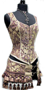 A Shrine classic!! A heavily constructed corset top in rich purple and ivory tapestry fabric with a great form fit. Heavy metal boning at sides and lycra stretch panel at back adds extra strong support. Fastens in front with seven large kilt pins but also zips in back for easy access. Rich ivory satin piping around armholes and neckline and ivory satin lining inside. Trimmed at the bottom with braided trim. 