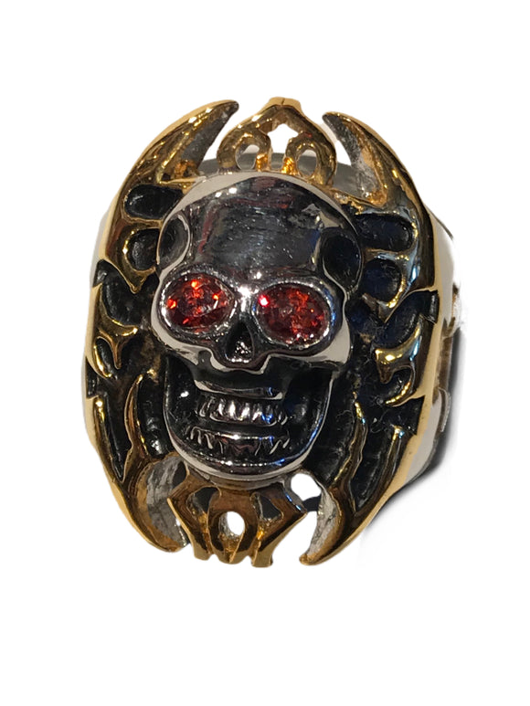 Skull ring with gold tinted cross background design and red gemstone eyes